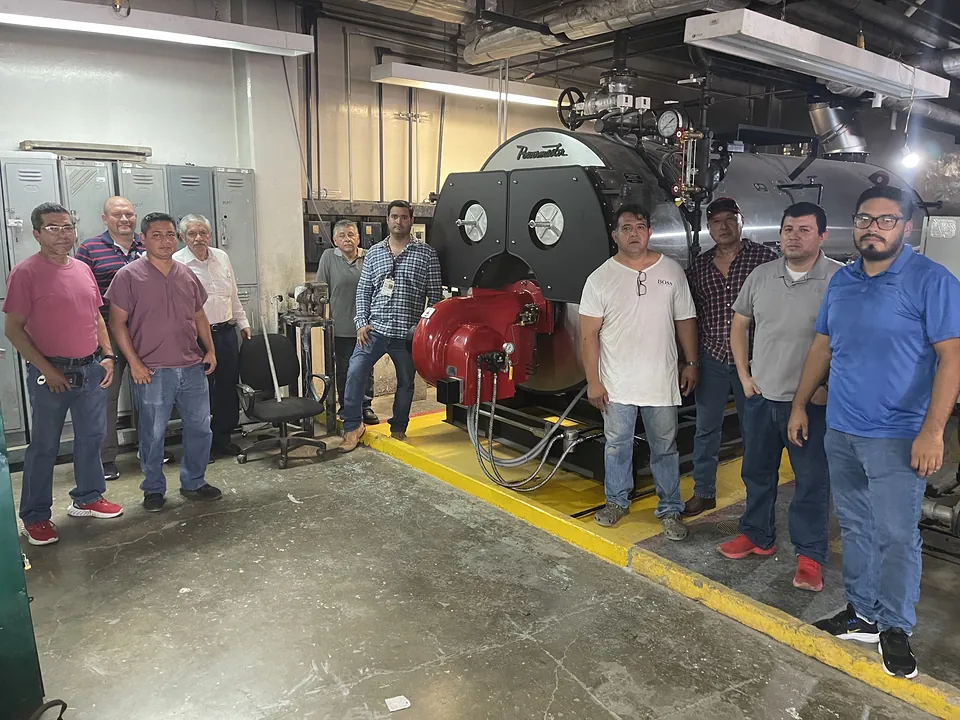Equipo de Termo Calderas con el cliente frente a una caldera Powermaster