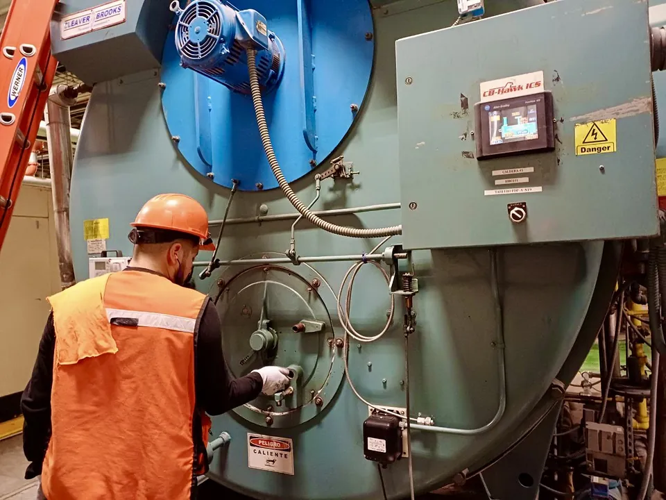 Técnico de Termo Calderas revisando el tablero de una caldera
